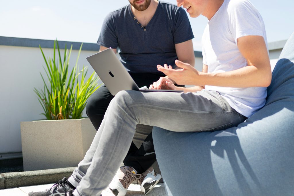 Photo of two people working on a laptop.