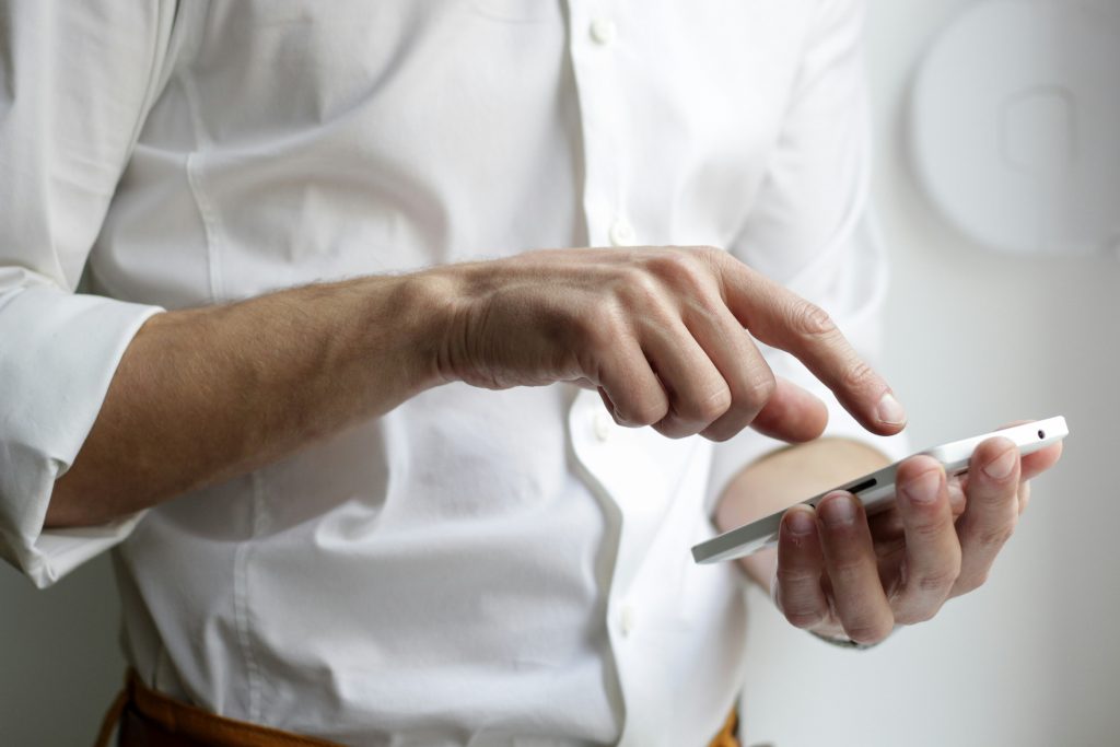 Photo of a man searching on his phone.